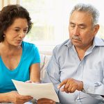 Hispanic couple reading printed documents together