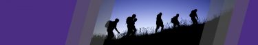 group of people walking up a hill together