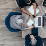 Team gathers around table.