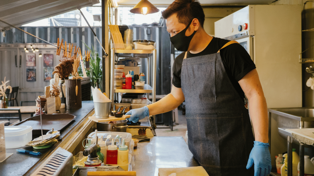 A small business employee prepares food in a restaurant kitchen.