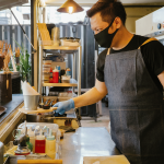 A small business employee prepares food in a restaurant kitchen.
